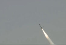 Iran Fires Dozens of Missiles at Israel After US-Backed Strikes Air defence intercepting missiles over Israeli city skyline at night