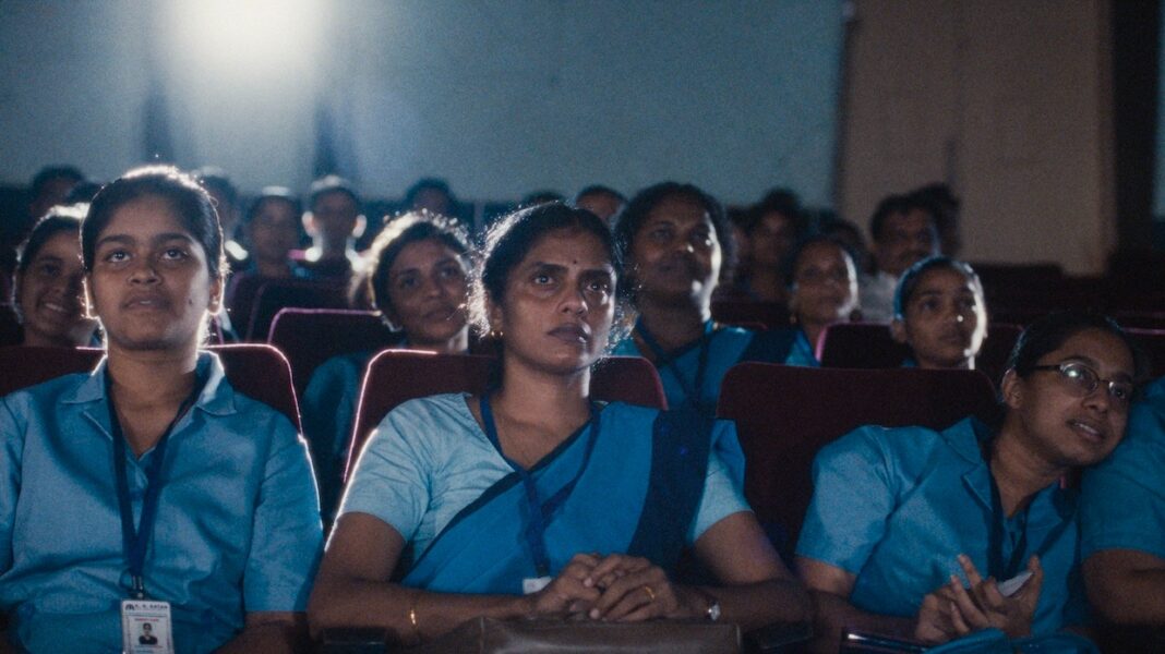 Young women watching a subtitled regional film with focused, thoughtful expressions