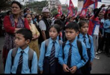 Dr. Sandesh Lamsal Foundation Accuses Harka Sampang’s Party of ‘Political Weaponisation of Minors’ in Nepal Protests School children standing near a political protest rally in Nepal amid crowds carrying party flags