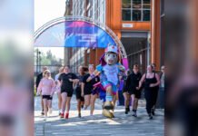 Glasgow Awaits: Commonwealth Games Return with a New Vision, New Heroes and Familiar Rivalries Participants run alongside the Glasgow 2026 Commonwealth Games mascot beneath the official Games entrance arch ahead of the opening ceremony.