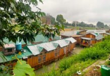 Children of the Floating World: Growing Up on Kashmir’s Fading Houseboats Traditional wooden houseboats on Dal Lake in Srinagar during a rainy day, where children grow up amid changing environmental conditions and daily challenges.