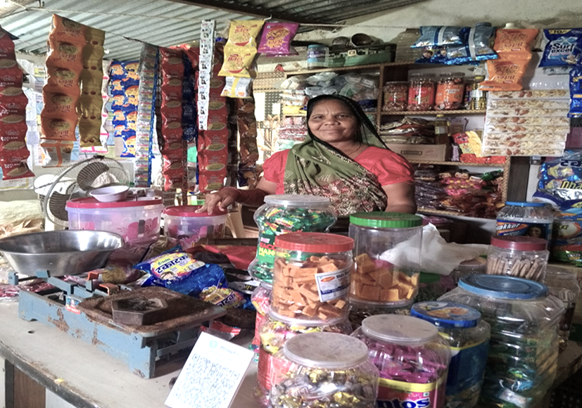 Amuli Devi Garasia stands behind the counter of her grocery shop in Banswara district, Rajasthan.
