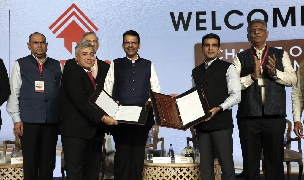 Officials display signed documents during an MoU ceremony at the NAREDCO Maharashtra event in Mumbai.