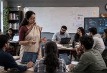Teachers’ Day Special: In the Age of AI & Smartphones, What Does It Mean to Be a Teacher Anymore? Indian teacher leading a classroom discussion with college-age students using laptops and digital tools, illustrating how AI and technology are changing teaching.